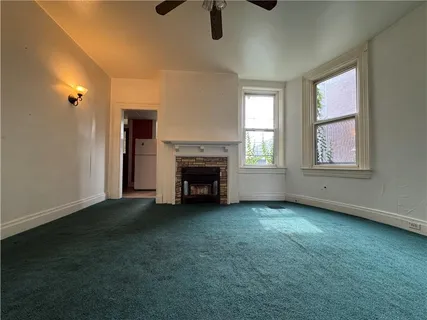 an empty room with fireplace and windows