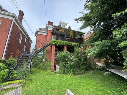 a front view of house with a garden