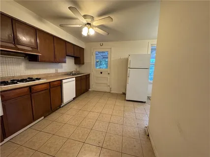 a kitchen with a sink a refrigerator and cabinets
