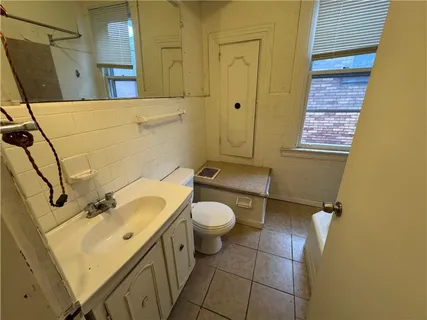 a bathroom with a toilet sink and mirror