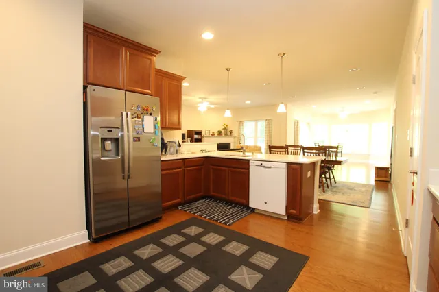 a kitchen with stainless steel appliances a refrigerator a sink a stove top oven and cabinets