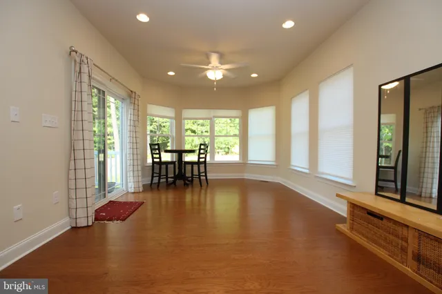 an empty room with floor to ceiling windows and wooden floor