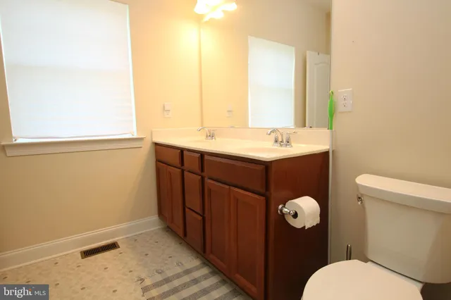 a bathroom with a sink mirror vanity and toilet
