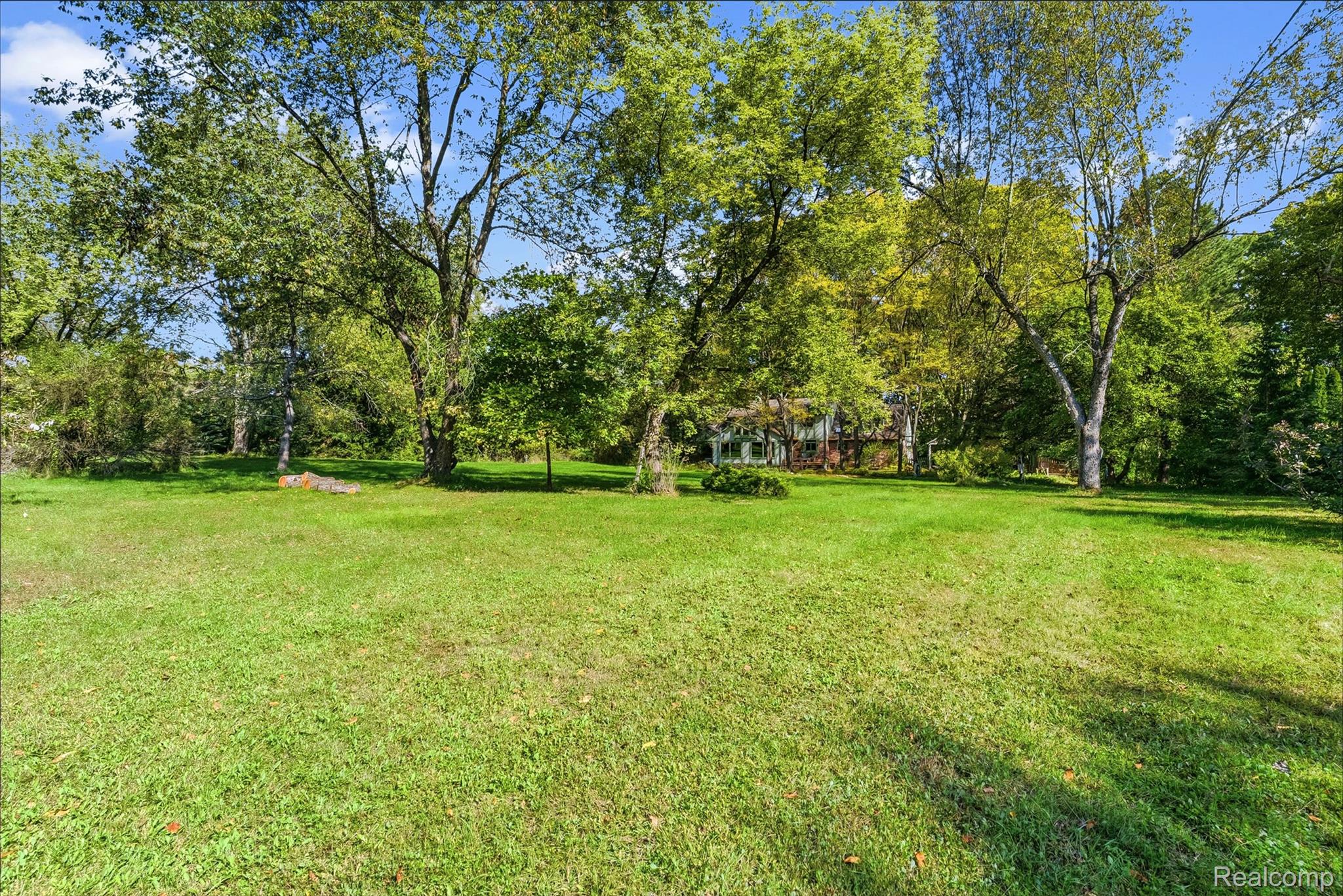 8135 Ranch Estates Road Clarkston, MI 48348 - Photo 44 of 53 Expansive grassy lawn surrounded by mature trees