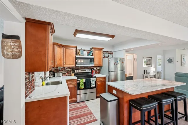 a kitchen with stainless steel appliances kitchen island granite countertop a table chairs in it and wooden floors