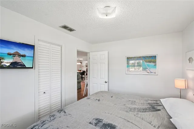 a bedroom with a bed and a painting on the wall