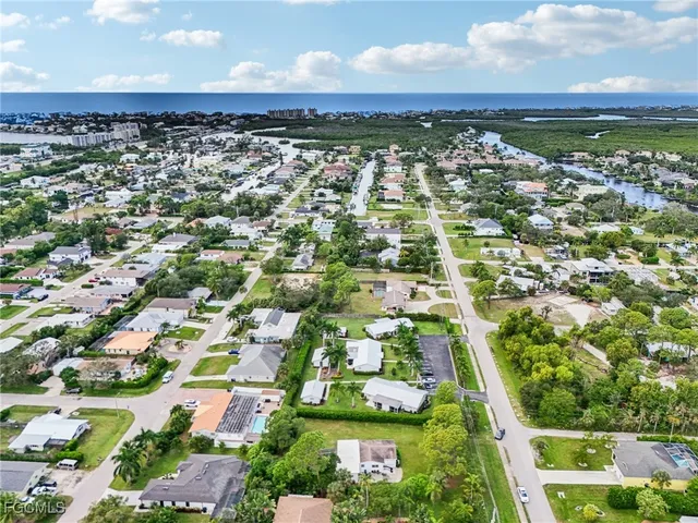 an aerial view of residential houses with outdoor space and trees
