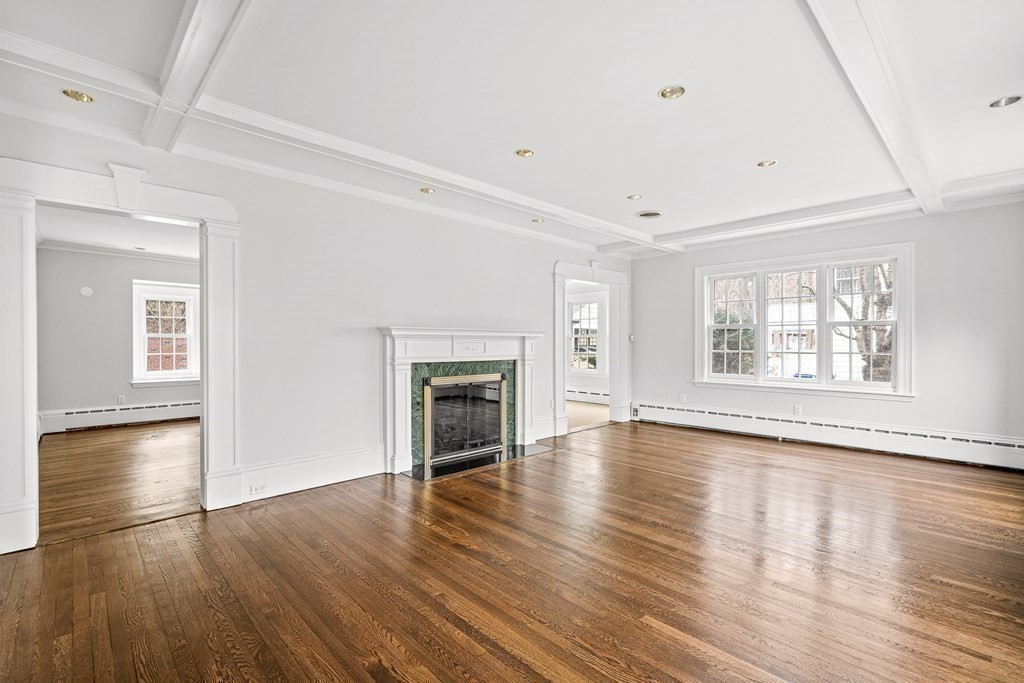 106 Clinton Road Brookline, MA 02445 - Photo 21 of 42 an empty room with wooden floor fireplace and windows