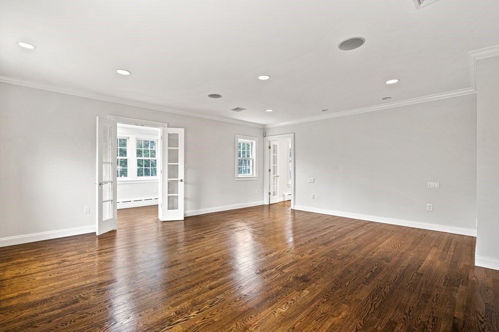 106 Clinton Road Brookline, MA 02445 - Photo 25 of 42 a view of an empty room with wooden floor and windows
