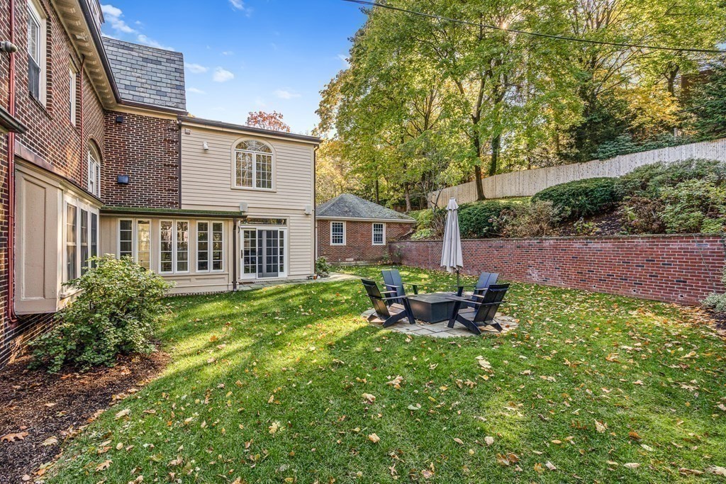 106 Clinton Road Brookline, MA 02445 - Photo 37 of 42 a view of a backyard with table and chairs potted plants and large tree