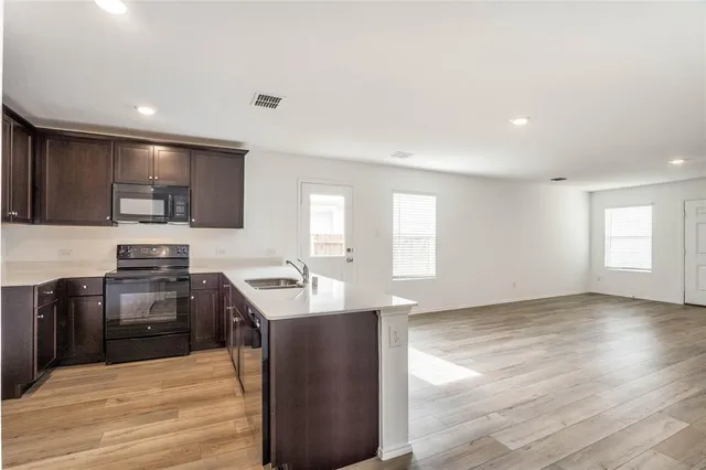 a kitchen with a sink stove and microwave