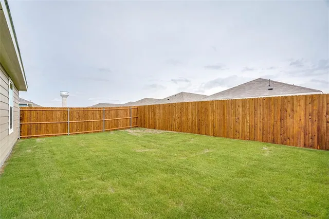 a view of yard with swimming pool and wooden fence