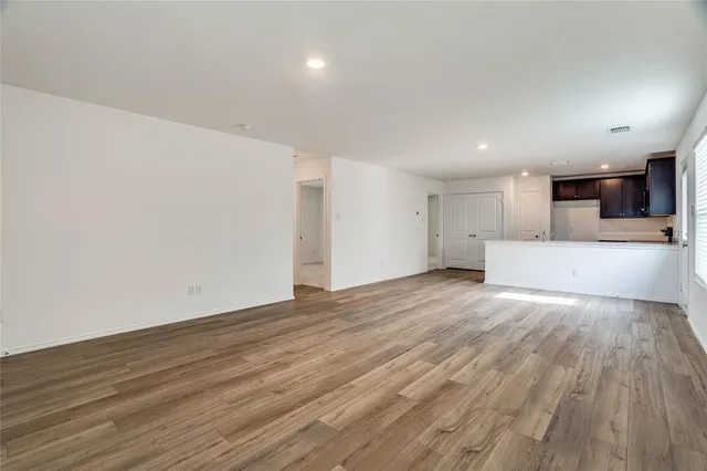 a view of a big room with wooden floor and large window