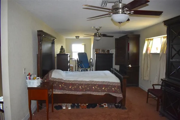 a bedroom with furniture and large windows