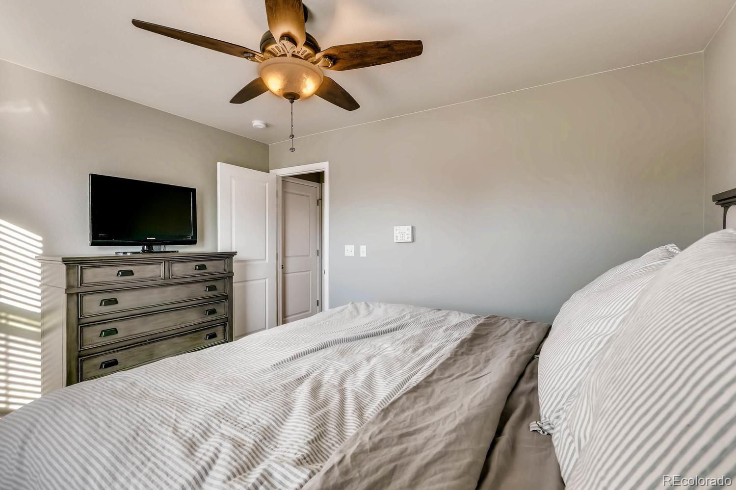 10261 Bellwether Lane Lone Tree, CO 80124 - Photo 12 of 35 a bedroom with a bed and a flat screen tv