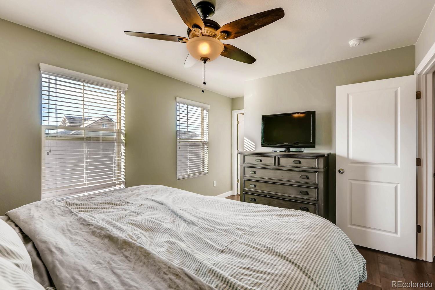 10261 Bellwether Lane Lone Tree, CO 80124 - Photo 13 of 35 a bedroom with a bed and a flat screen tv