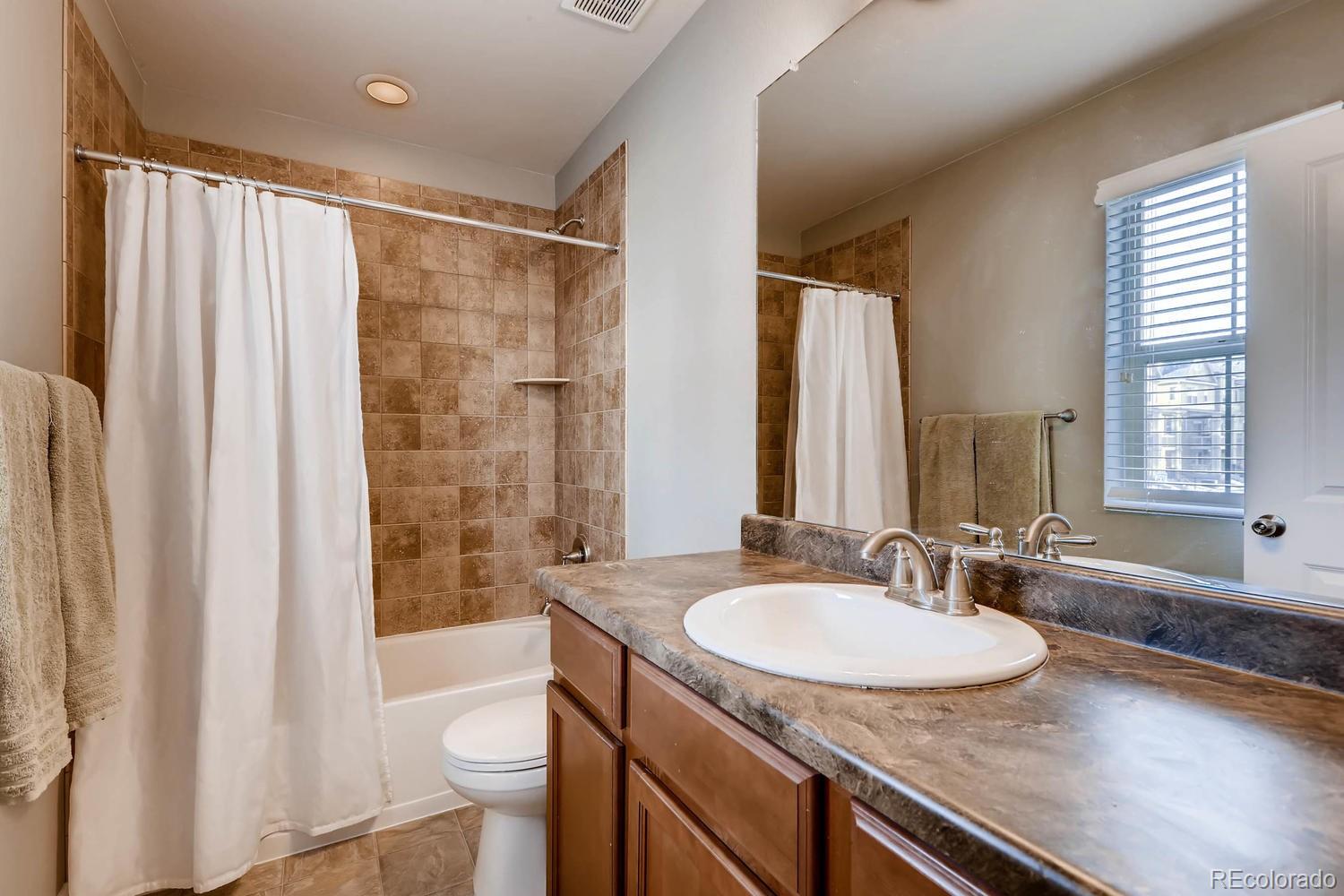 10261 Bellwether Lane Lone Tree, CO 80124 - Photo 18 of 35 a bathroom with a granite countertop sink toilet and shower