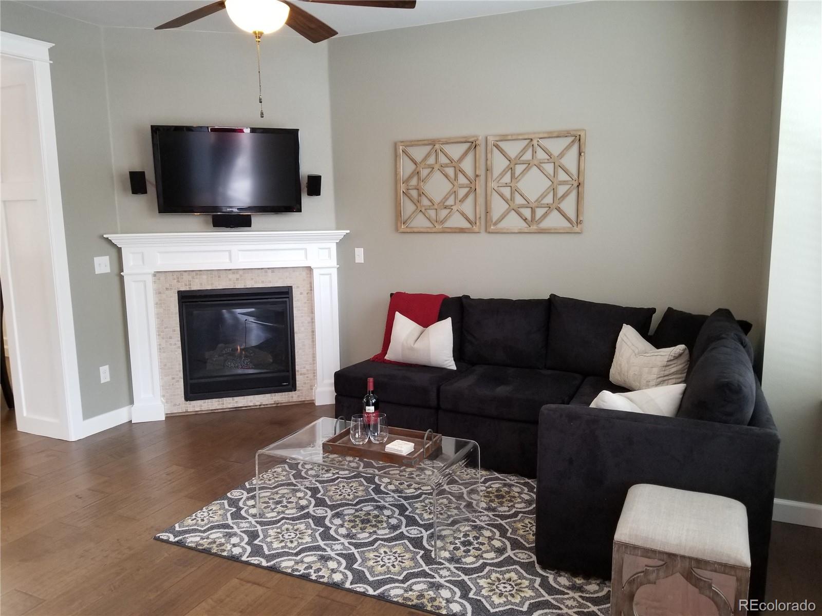 10261 Bellwether Lane Lone Tree, CO 80124 - Photo 5 of 35 a living room with furniture a fireplace and a flat screen tv