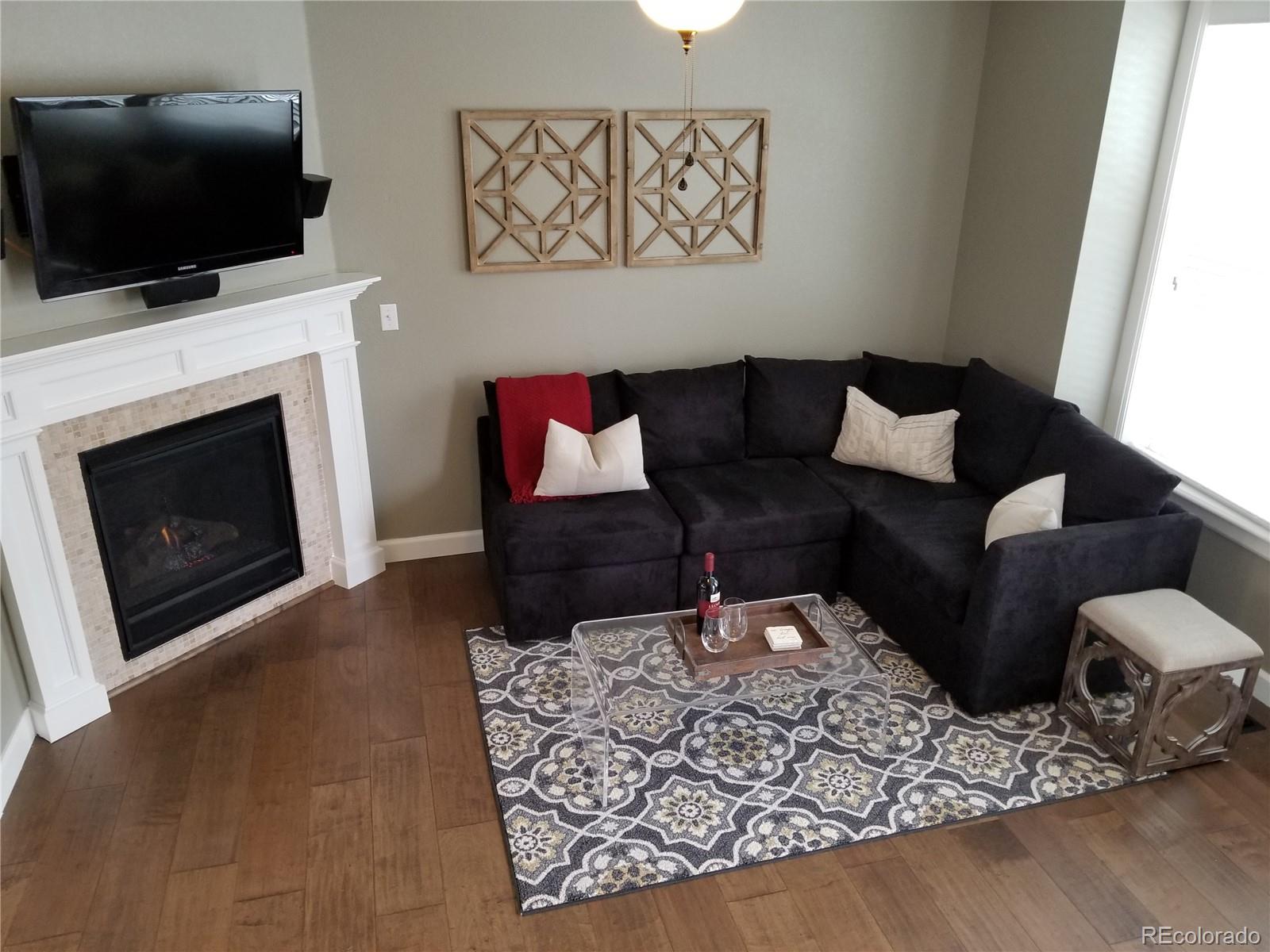 10261 Bellwether Lane Lone Tree, CO 80124 - Photo 6 of 35 a living room with furniture a flat screen tv and a fireplace