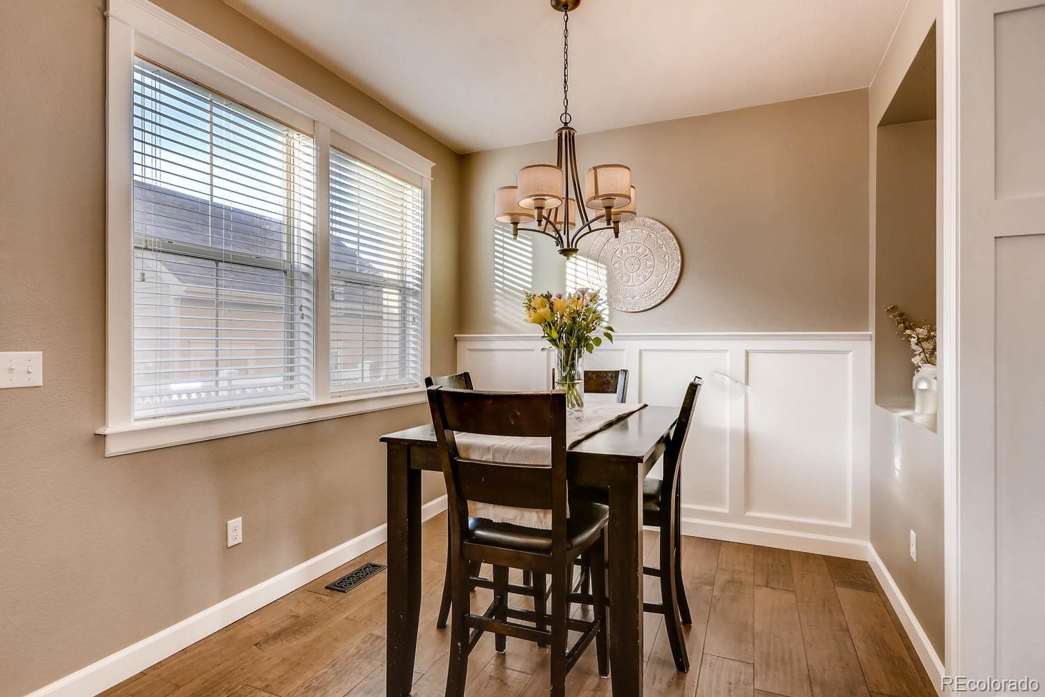 10261 Bellwether Lane Lone Tree, CO 80124 - Photo 8 of 35 a dining room with chandelier and wooden floor