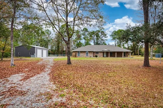 a front view of a house with yard and tree