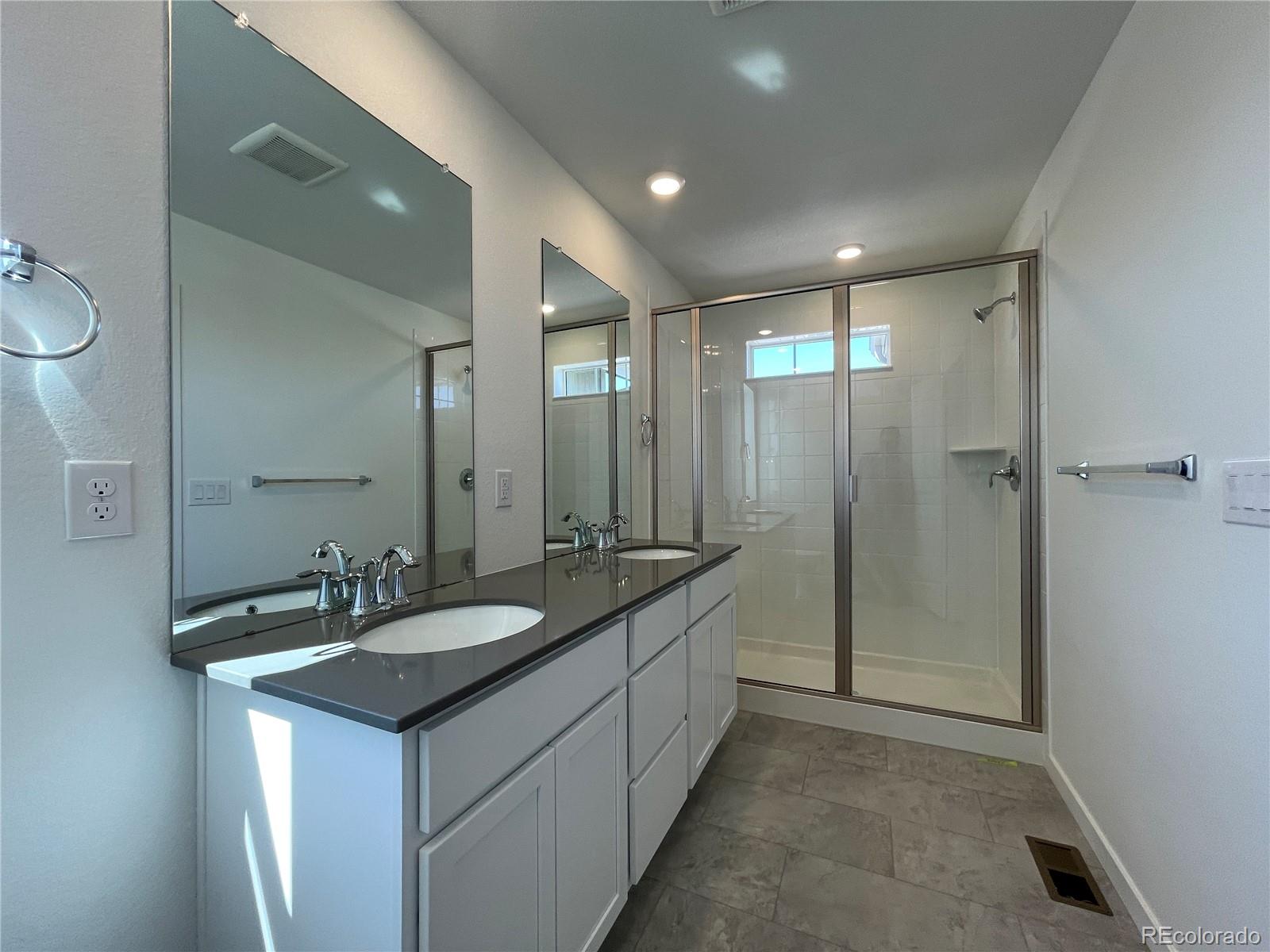 755 Yankee Boy Loop Elizabeth, CO 80107 - Photo 17 of 31 a bathroom with a double vanity sink and mirror with shower