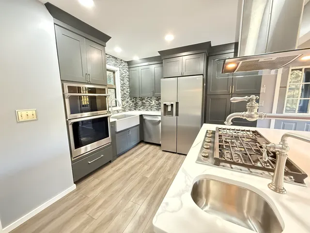 a kitchen with stainless steel appliances granite countertop a sink and a stove