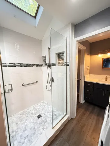 a bathroom with a glass shower door and a sink