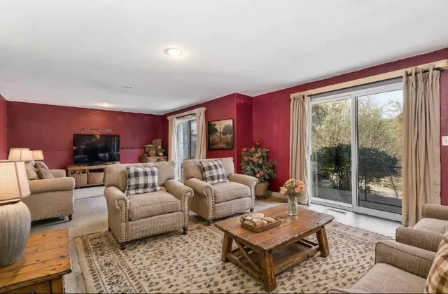 a living room with furniture floor to ceiling window and a table
