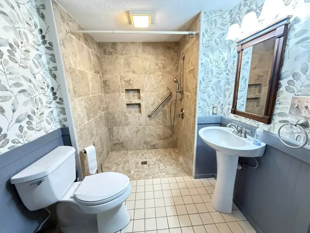 a bathroom with a sink toilet and shower