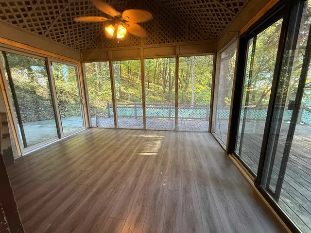 a view of empty room with wooden floor and iron stairs