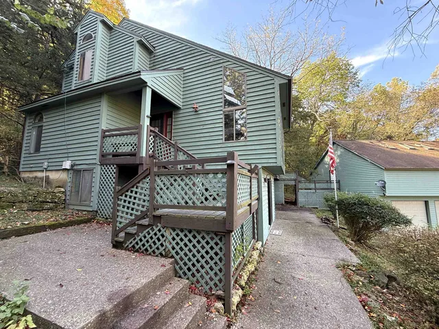 a view of a house with a small yard and wooden fence