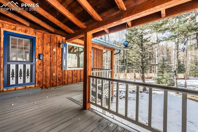an empty room with wooden floor fireplace and windows
