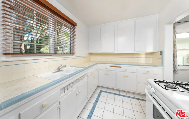 a kitchen with a sink stove and cabinets