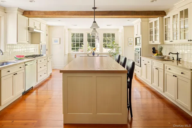 a kitchen with stainless steel appliances a stove a sink a microwave and cabinets