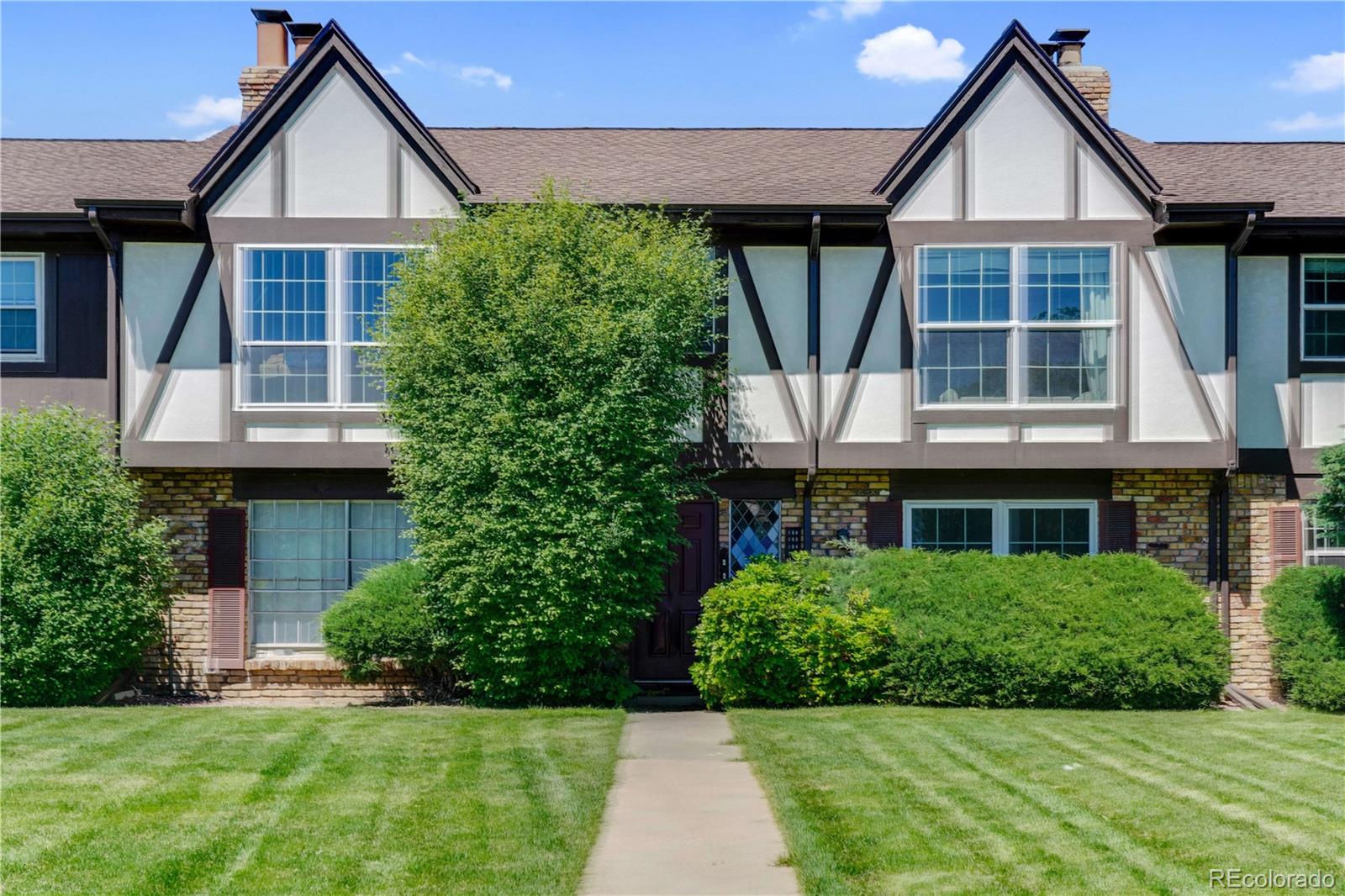 3855 South Monaco Street, Unit 203 Denver, CO 80237 - Photo 20 of 26 a front view of a house with a yard and potted plants