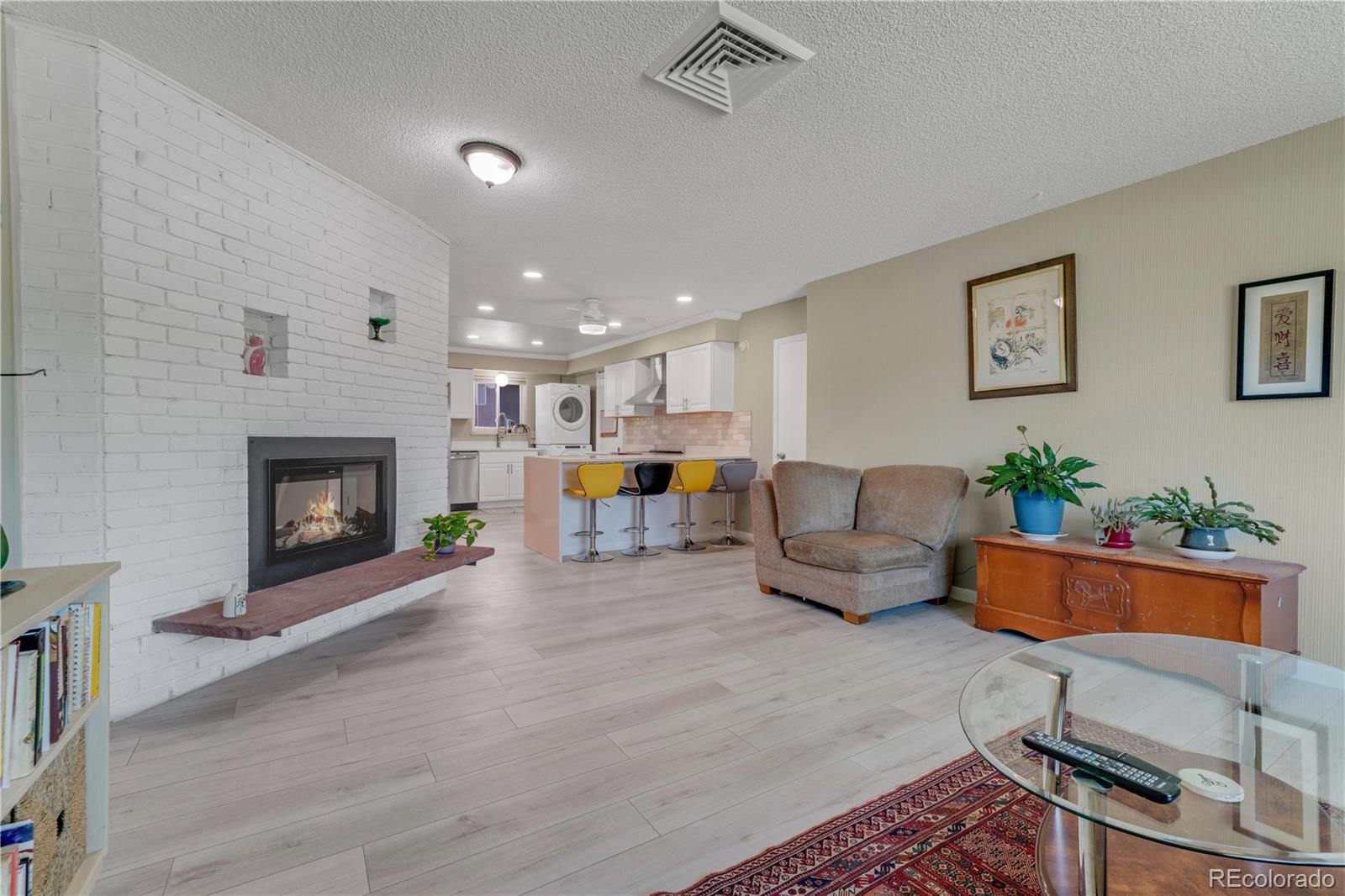 3855 South Monaco Street, Unit 203 Denver, CO 80237 - Photo 3 of 26 a living room with furniture and a fireplace