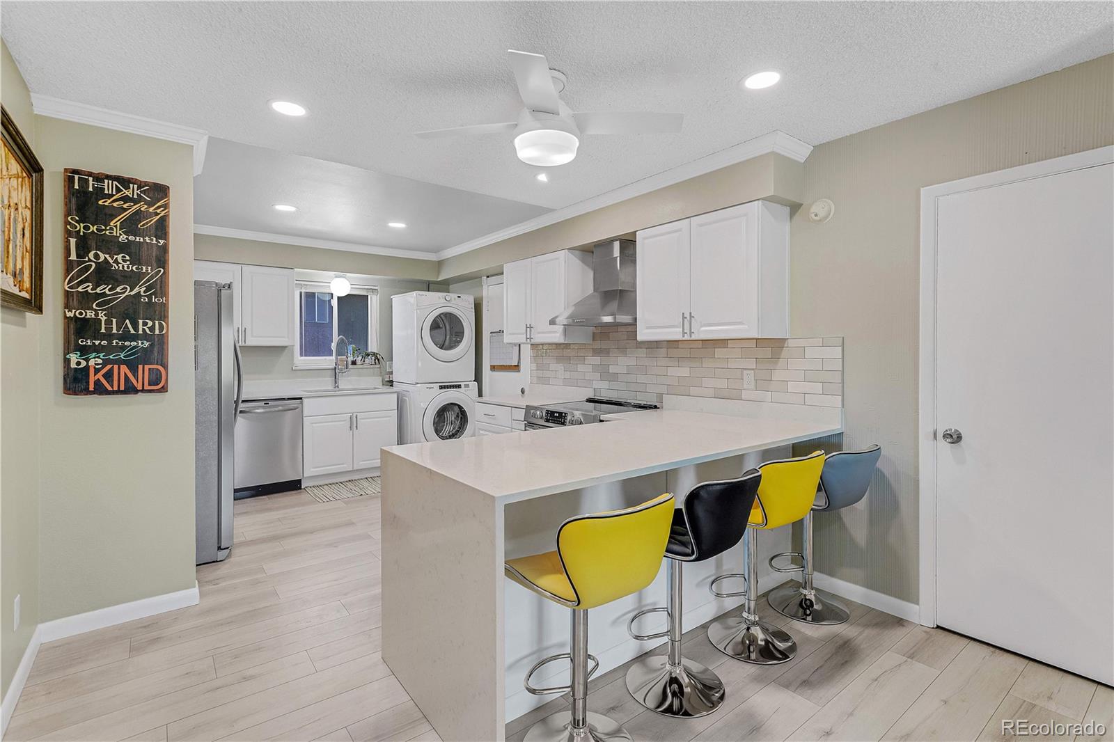 3855 South Monaco Street, Unit 203 Denver, CO 80237 - Photo 6 of 26 a kitchen with stainless steel appliances a stove a sink cabinets and a refrigerator