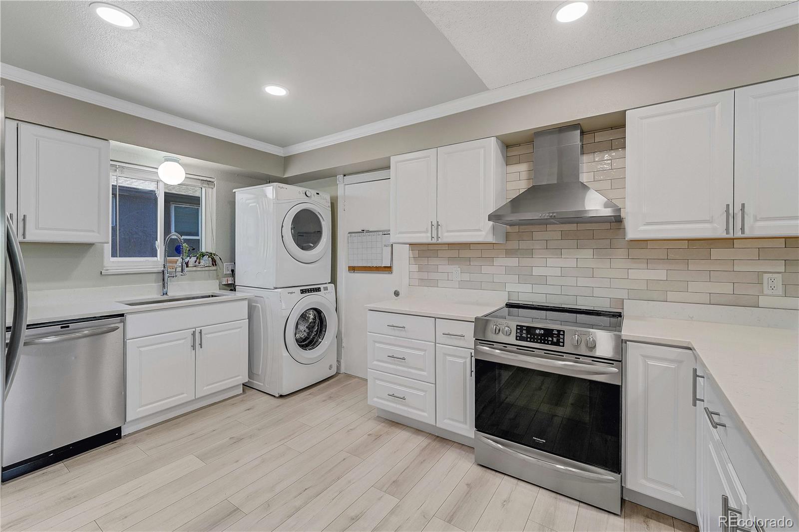 3855 South Monaco Street, Unit 203 Denver, CO 80237 - Photo 7 of 26 a kitchen with stainless steel appliances granite countertop a stove and white cabinets