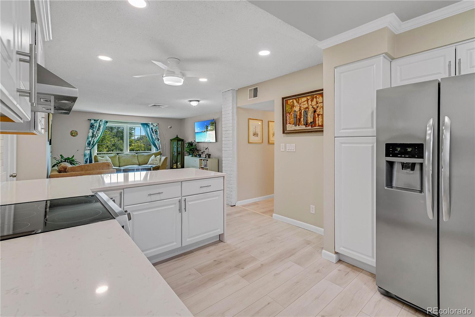 3855 South Monaco Street, Unit 203 Denver, CO 80237 - Photo 9 of 26 a kitchen with stainless steel appliances kitchen island granite countertop a refrigerator and a sink