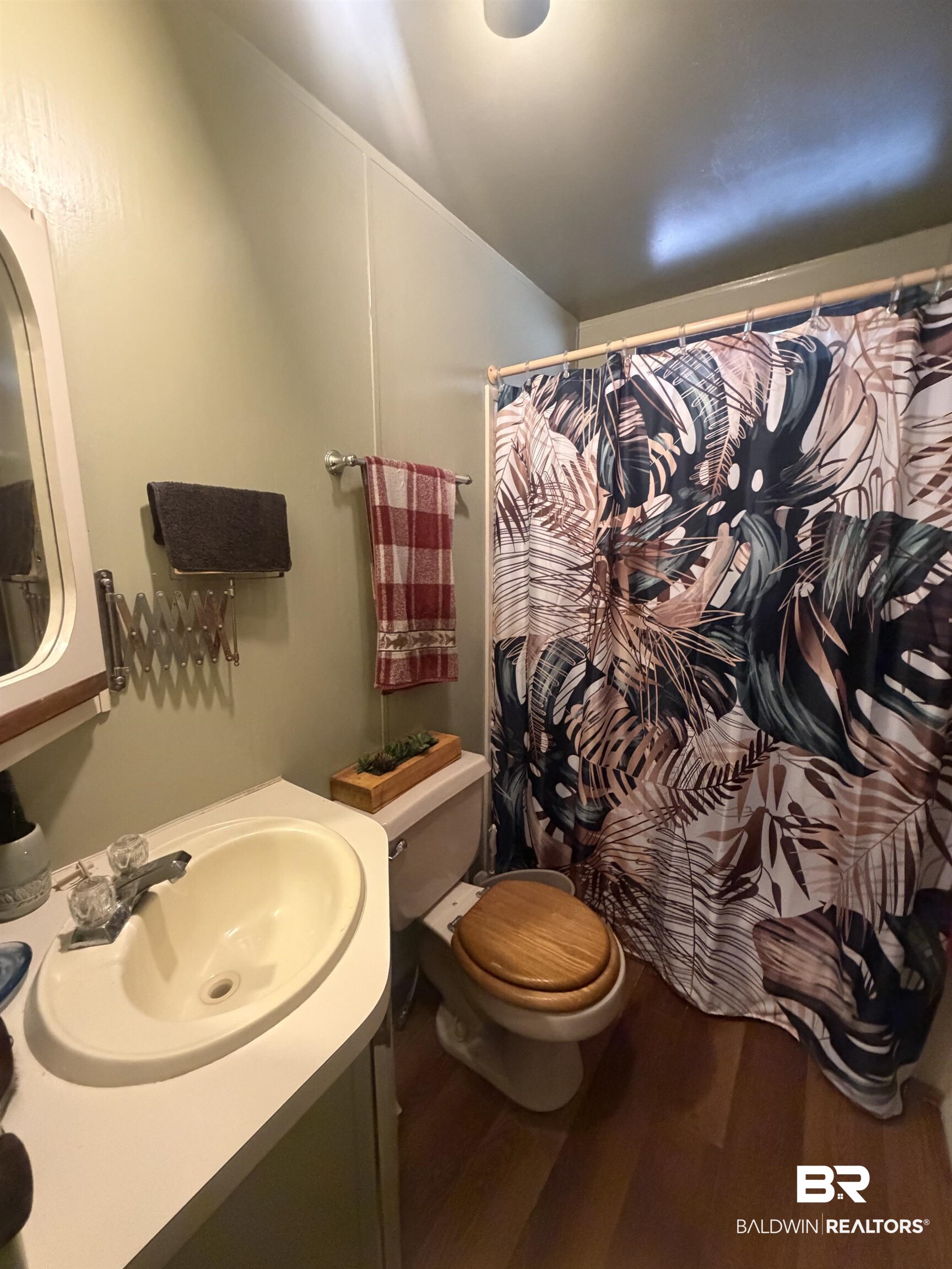 1620 Del Rey Drive Lillian, AL 36549 - Photo 19 of 45 Bathroom featuring a vanity with an integrated sink, polished chrome faucet, and a wood-finish toilet seat
