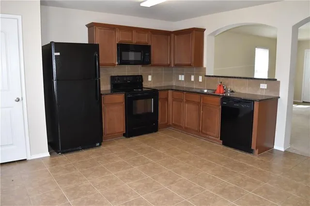 a kitchen with a refrigerator and a stove top oven