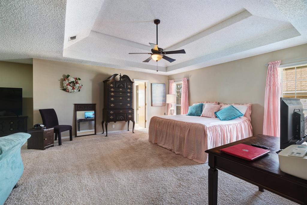 925 Medalist Street Paris, TX 75460 - Photo 11 of 24 a bedroom with bed and a chandelier