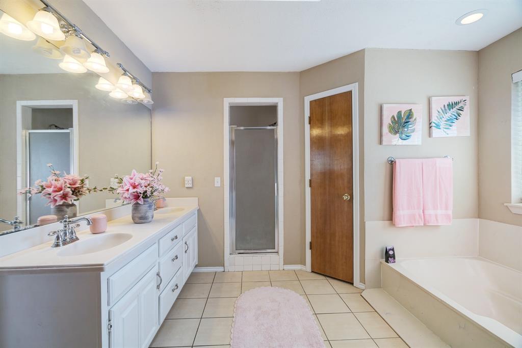 925 Medalist Street Paris, TX 75460 - Photo 14 of 24 a bathroom with a double vanity sink mirror and bathtub