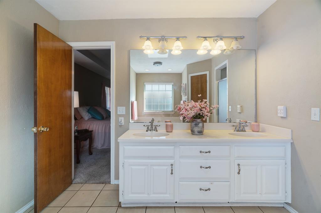 925 Medalist Street Paris, TX 75460 - Photo 15 of 24 a bathroom with a double vanity sink and a mirror