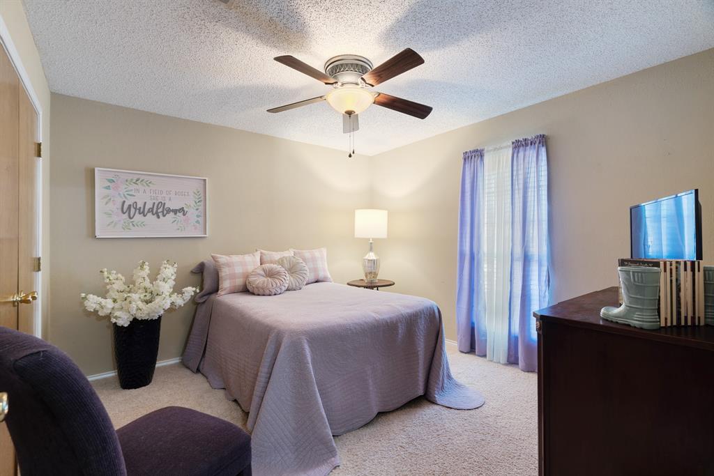 925 Medalist Street Paris, TX 75460 - Photo 17 of 24 a bedroom with a bed and ceiling fan