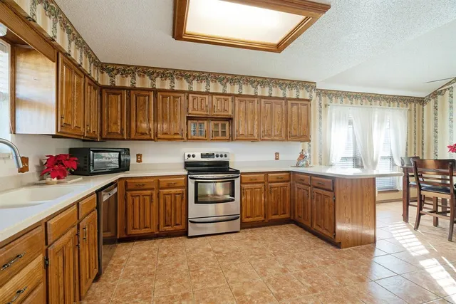 a kitchen with stainless steel appliances granite countertop a stove sink and cabinets
