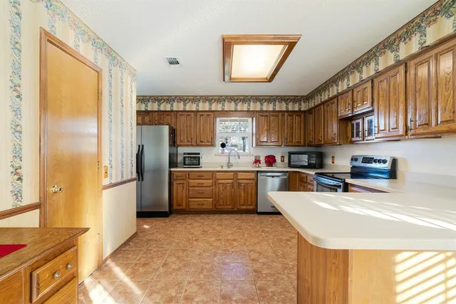 a kitchen with stainless steel appliances a refrigerator and a stove top oven