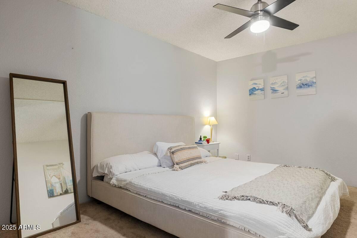 7625 East Camelback Road, Unit B151 Scottsdale, AZ 85251 - Photo 12 of 16 a bedroom with a bed and a ceiling fan