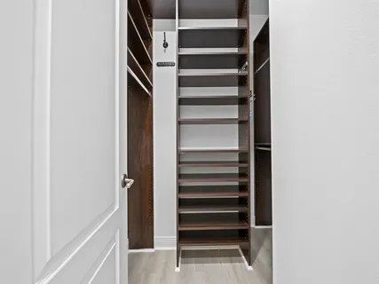 a view of walk in closet with empty racks